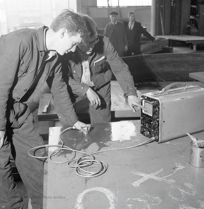 Photographs of apprentices being shown a job