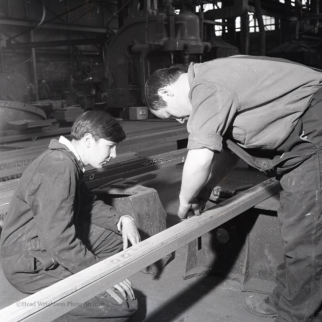 Photographs of apprentices being shown a job