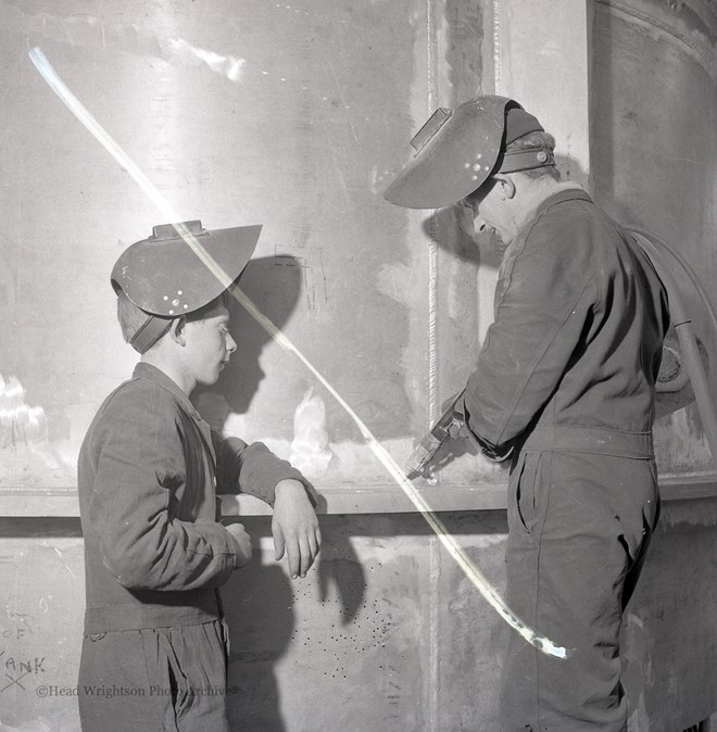 Photographs of apprentices being shown a job