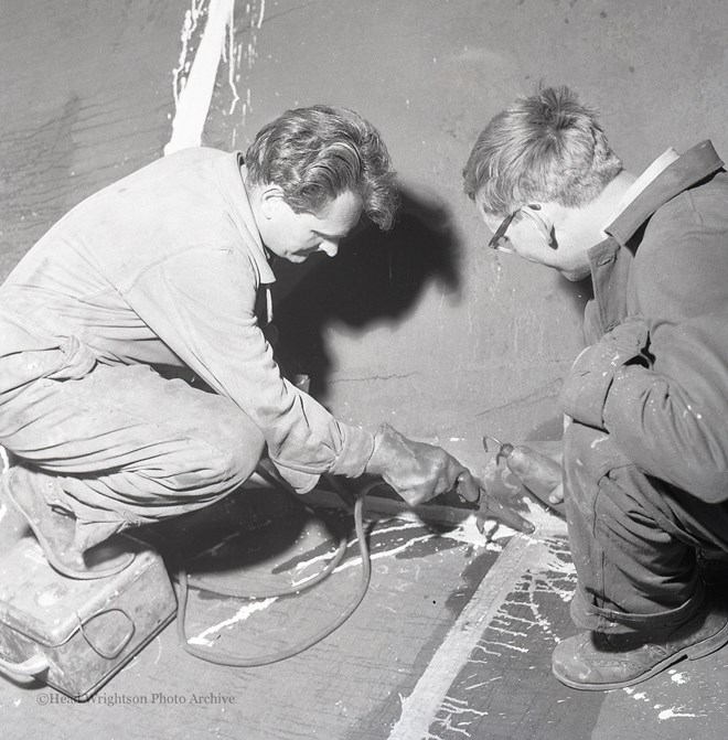 Photographs of apprentices being shown a job