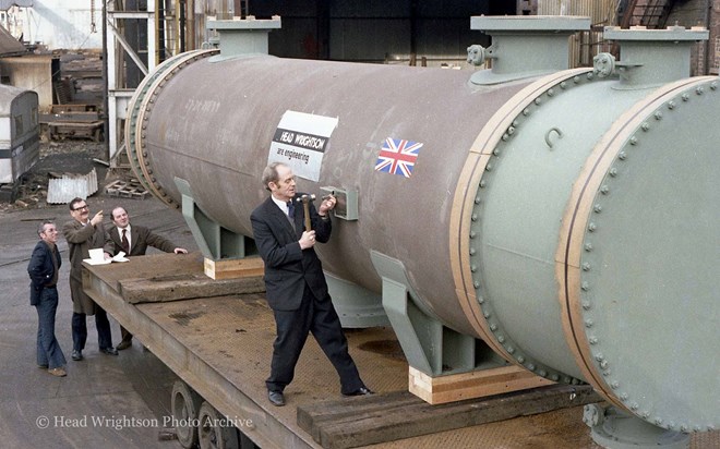 3 men looking at large pipe