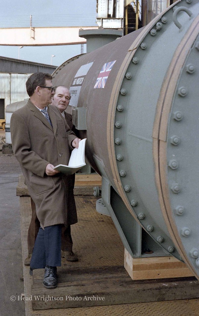 3 men looking at large pipe