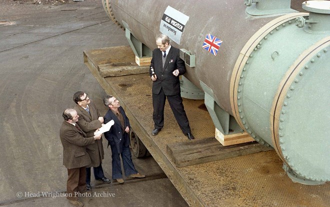 3 men looking at large pipe