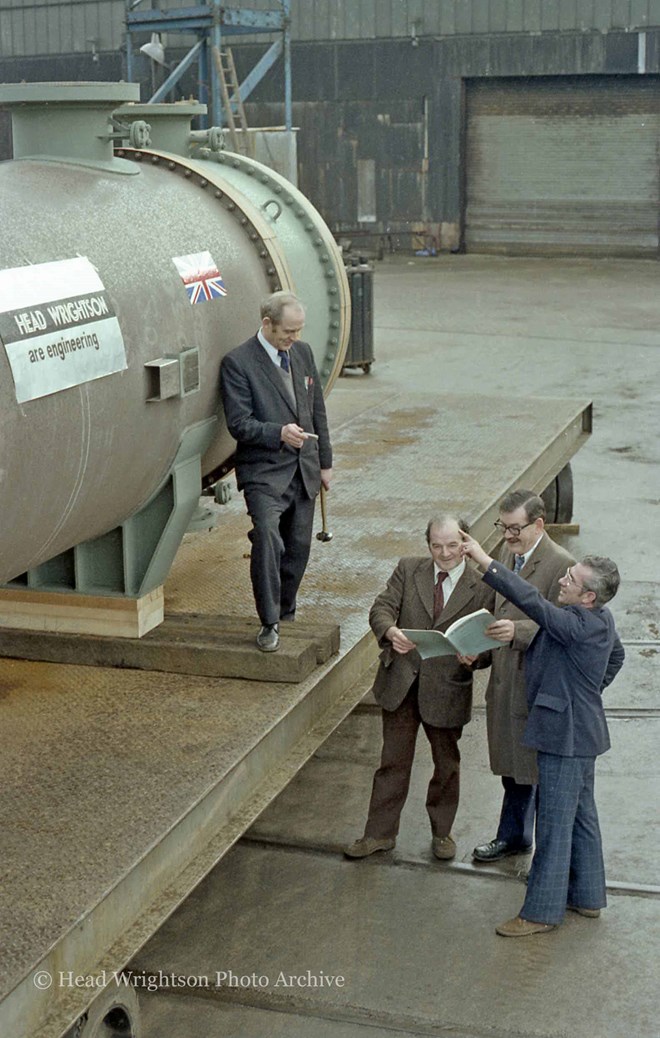 3 men looking at large pipe