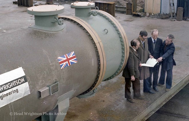 3 men looking at large pipe