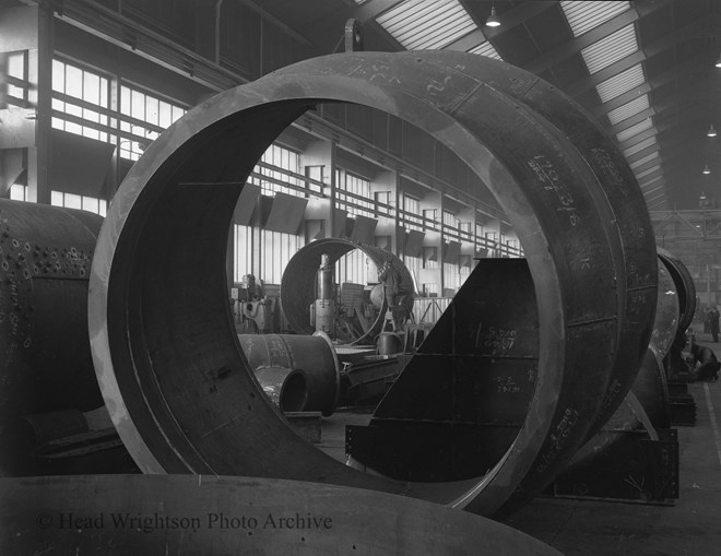 View through hopper to man welding